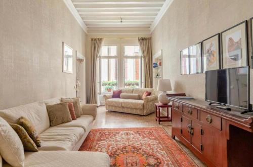 a living room with a couch and a flat screen tv at Venezia San Samuele in Venice