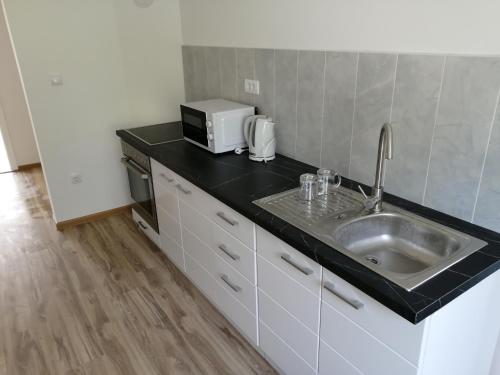 a kitchen with a sink and a microwave at Family hоuse in Banja Koviljača