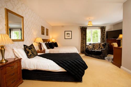 ドニゴールにあるDonegal Manorのベッド2台と鏡が備わるホテルルームです。