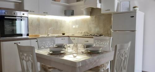 サンタ・マリア・アル・バーニョにあるCasa Carlottaの白いキッチン(テーブル、ボウル付)