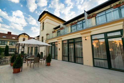 a patio with a table and chairs and a building at Elizabeth Hotel in Gyula