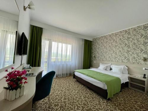 a hotel room with a bed and a desk and a room at Hotel Complex Turistic Magura in Măgura