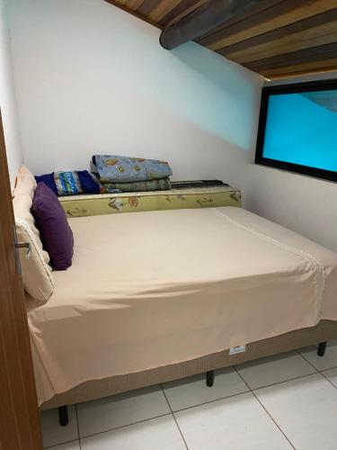 uma cama num quarto com uma televisão de ecrã plano em Winterville Gravata em Gravatá