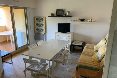 un salon avec une table, des chaises et un canapé dans l'établissement Apartment With Sea View, à Six-Fours-les-Plages