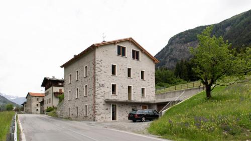 a car parked in front of a building on a road at Italianway - Villa Tola in Valdisotto