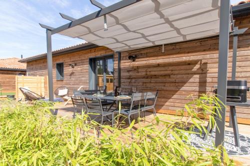 un patio avec une table et des chaises sous un parasol dans l'établissement Maison Gemme a Landes, à Léon