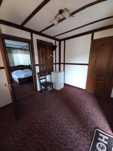 a room with a bed and a chair and a door at Family House in Makarovka