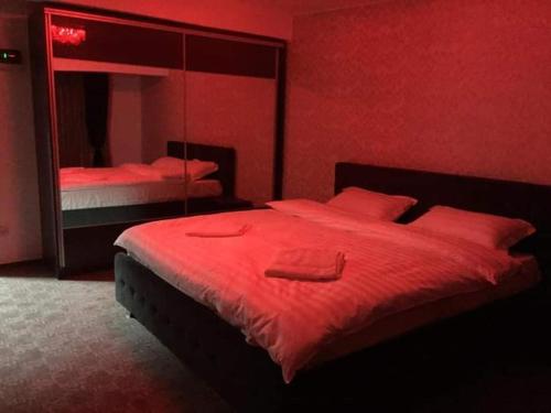 a red bedroom with a bed and a mirror at Ely's Mansion-24h Check-in in Bucharest