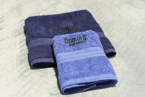 para fioletowych ręczników siedzących na łóżku w obiekcie DOMINO-APARTAMENTY Blue w Krościenku