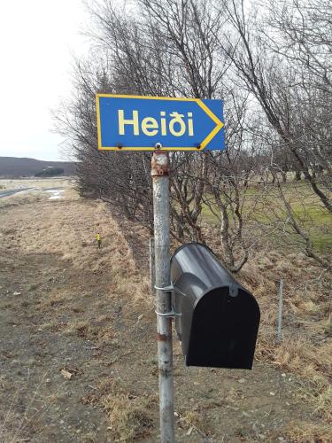 a blue hello sign on a pole with a television at Heidi Guesthouse in Selfoss