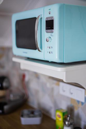 a microwave sitting on top of a shelf at Alsóörs Pagony in Alsóörs