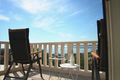 - un balcon avec une chaise et une table avec une bouteille dans l'établissement Apartments Mi&Ni, à Cavtat