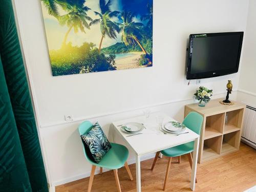 a dining room with a table and chairs and a tv at LE COSY - Lumineux - Proche de Rennes - Spacieux in Liffré