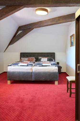 a bedroom with a bed and a red carpet at Vila Lovců králových in Český Krumlov