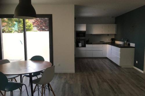 a kitchen and dining room with a table and chairs at Aux portes de La Rochelle - Un air de campagne au bord de mer in Marsilly