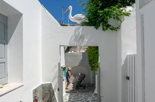 a man standing in a hallway with a white building at Pelican Paros in Parikia