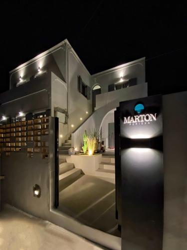 a sign for a marion store at night at Marton Perissa in Perissa