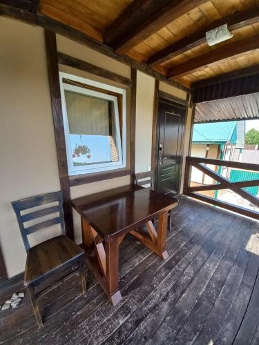 a wooden table and a chair in a room at Family House in Makarovka