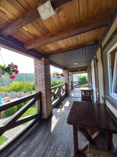 a porch of a house with a wooden table at Family House in Makarovka