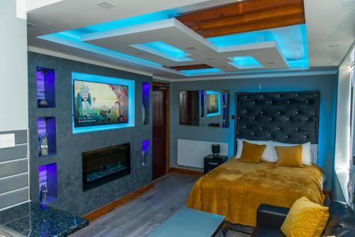 1 dormitorio con 1 cama con luces azules en el techo en Sawrey Serviced Apartments, en Bradford