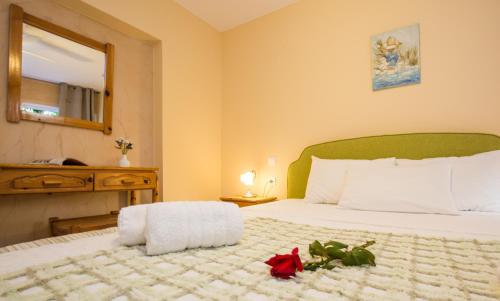 a bedroom with a bed with a red flower on it at Limonero New City Apartment 1 with Private Parking in Lefkada Town
