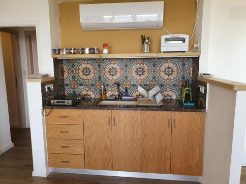 a kitchen with a sink and a wall at Switzerland In Amirim in Amirim