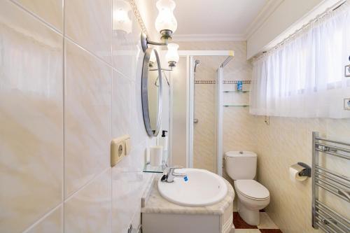 ein Badezimmer mit einem Waschbecken, einem WC und einem Spiegel in der Unterkunft Miramar Magic Sea & Sunrise view in Torrevieja