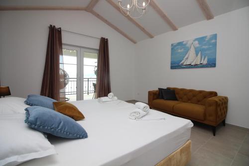 1 Schlafzimmer mit 2 Betten und einem Sofa in der Unterkunft Villa Beachfront Sea Palace in Kaštela
