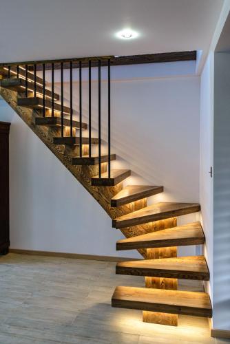 a staircase with wooden treads in a room with white walls at Domek Kaszuby Sominy Luxhut in Sominy
