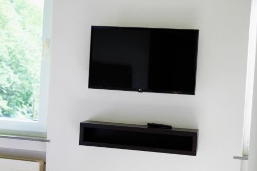 a flat screen tv hanging on a wall at Rheinsteig Quartier by bestprice Hotels in Bendorf