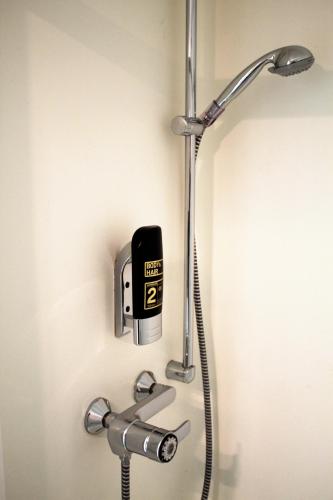 a shower in a bathroom with a faucet at bestprice Hotel Bendorf Koblenz in Bendorf