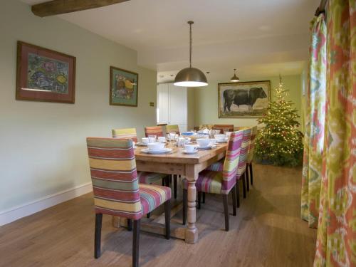 a dining room with a table with chairs and a christmas tree at Yellison at Broughton Sanctuary in Skipton