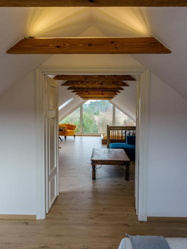 an attic room with a vaulted ceiling and an open door at Domek Kaszuby Sominy Luxhut in Sominy