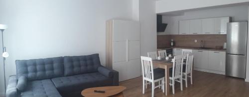 a living room with a couch and a table and a kitchen at Apartamenty Irena Stare Miasto Św. Ducha in Elblag
