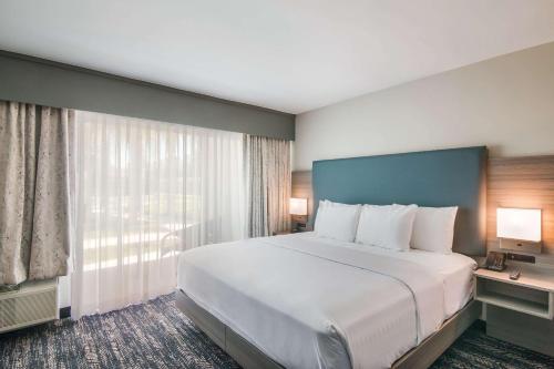 a large bed in a hotel room with a large window at Hourglass Hotel, Ascend Hotel Collection in Bakersfield