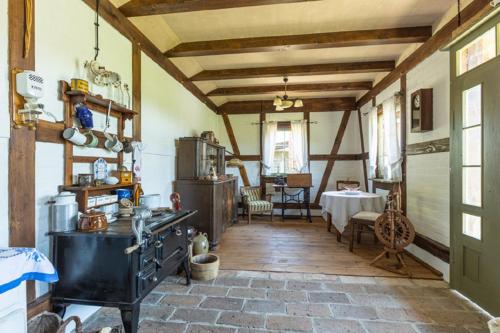 - une cuisine ancienne avec une cuisinière et une table dans l'établissement Bauernhof Ladusch, à Kolonie Baruther Berg