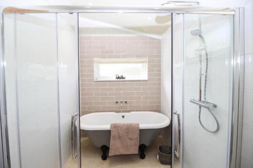 e bagno con vasca e doccia. di Hollicarrs - Kingfisher Lodge a York