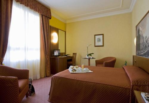 Un pat sau paturi într-o cameră la Hotel President