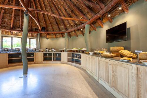 a large room with a large kitchen with a tv at Aquila Private Game Reserve & Spa in Touwsrivier