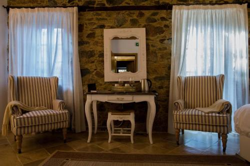 a bedroom with a table and two chairs and a mirror at Aristotelio Boutique Hotel in Pedoulas