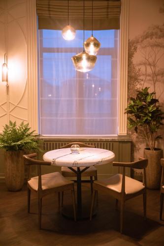 a table and two chairs in a room with a window at Amsterdam Hotel Aktobe in Aktobe