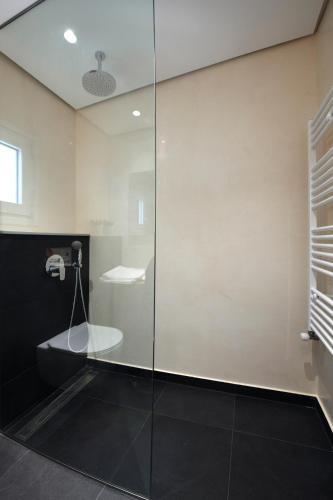 a bathroom with a shower with a glass door at m2studio in Kavala