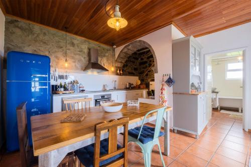 a kitchen with a wooden table and a blue refrigerator at Casa Luz in Nordeste
