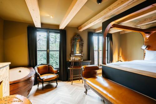 a bedroom with a bed and a tub and a chair at Boutique Hotel The Noblemen in Amsterdam