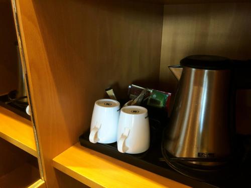 two rolls of toilet paper on a shelf with a coffee pot at Havila Hotel Raftevold in Hornindal