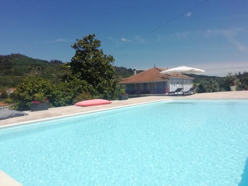 a large swimming pool in front of a house at Quinta da Tapada in Avô