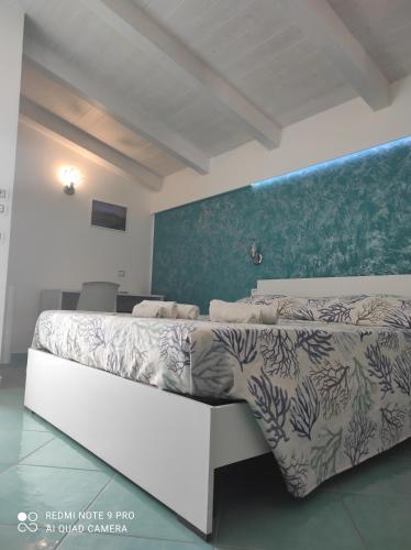 una camera con un letto bianco e una parete verde di Residenza Porta Romana a Tropea