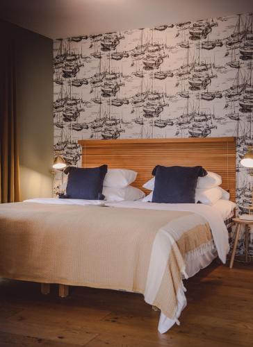 a bedroom with a large white bed with a wallpaper at Clubhaus Bachmair Weissach in Tegernsee