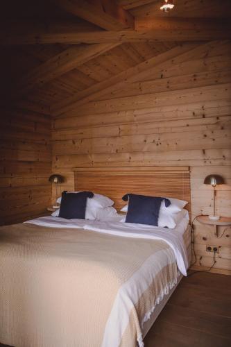 a bedroom with a large bed in a log cabin at Clubhaus Bachmair Weissach in Tegernsee