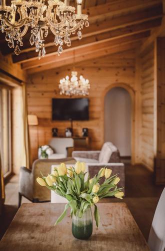a dining room with a table with a vase of yellow flowers at Clubhaus Bachmair Weissach in Tegernsee